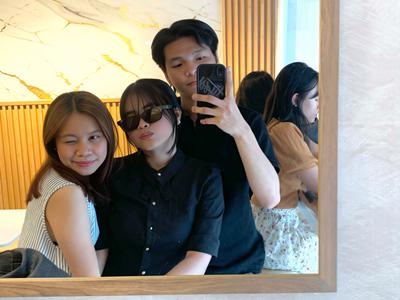 a group of people sitting in front of a mirror posing for the camera