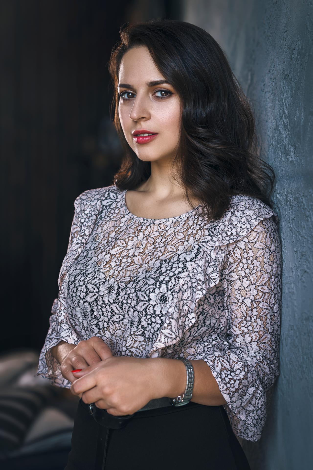 young-woman-floral-top-looking-cameradreeamstudio