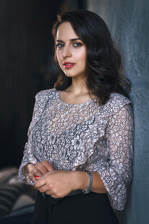 young-woman-floral-top-looking-cameradreeamstudio