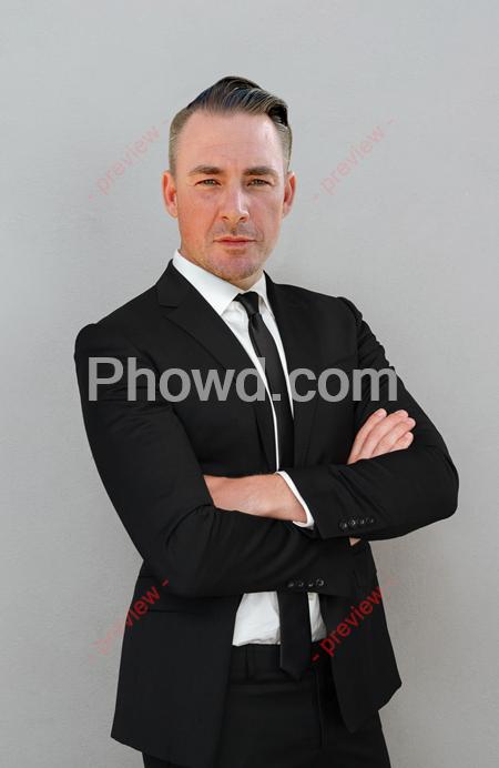 confident-young-businessman-suit-standing-with-arms-folded-01